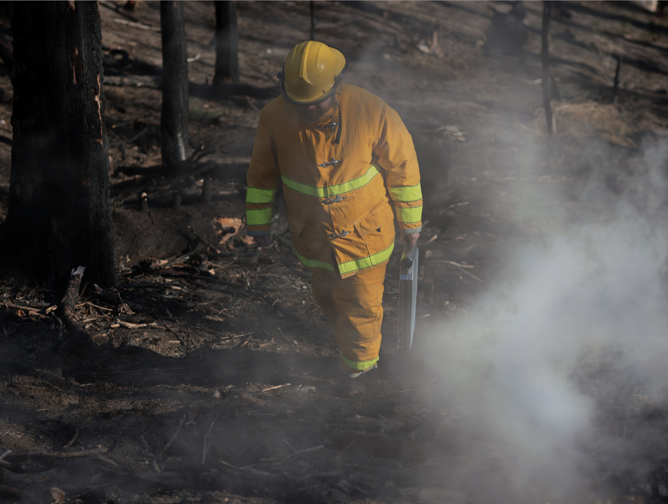 A first responder carrying a Satcube terminal on a burn site